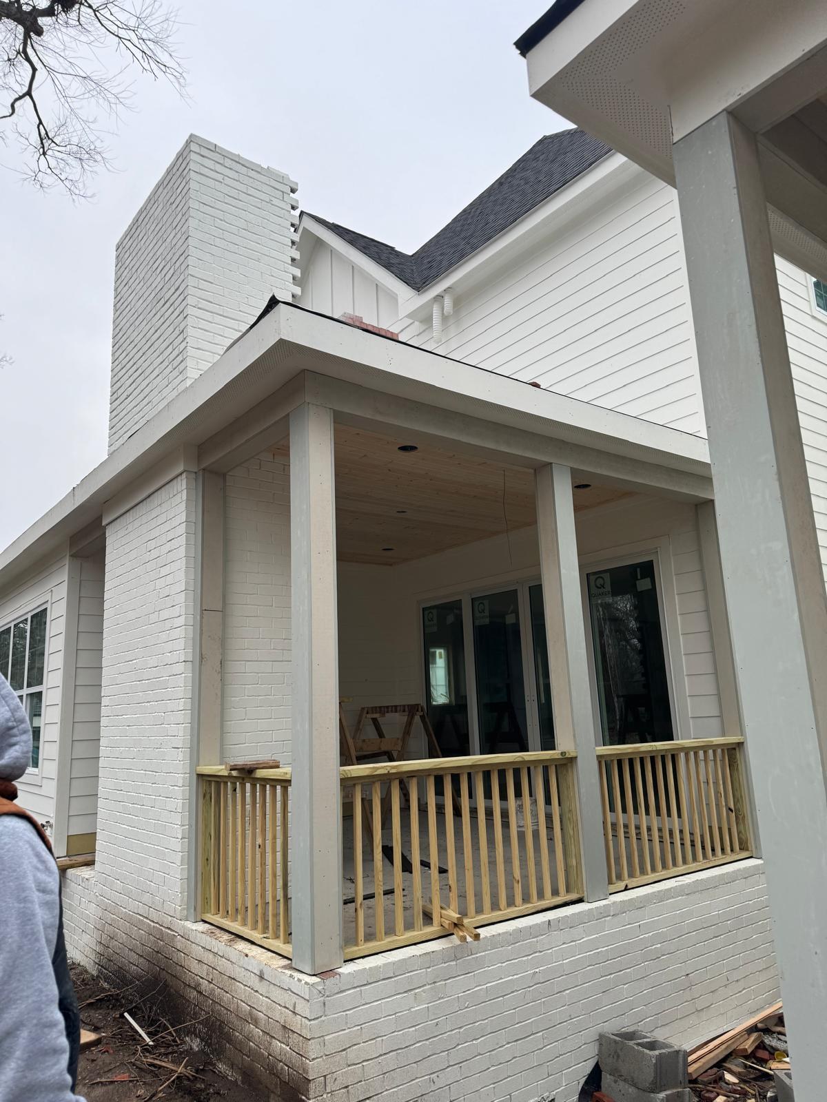 A freshly painted white brick home with a covered porch