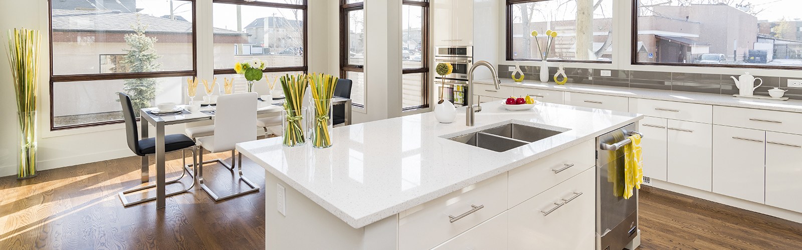A bright finished kitchen with white cabinets and a large island