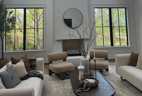 A bright, freshly finished living room with a fireplace and large windows