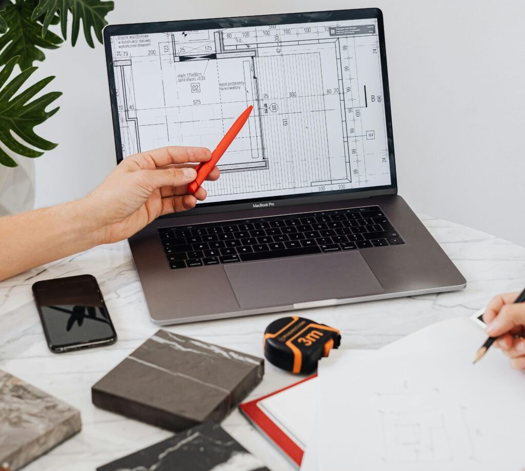 A laptop showing remodeling plans alongside material samples