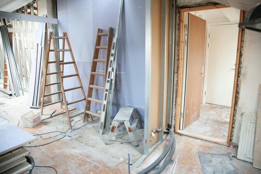 A room mid-renovation with ladders and fresh framing